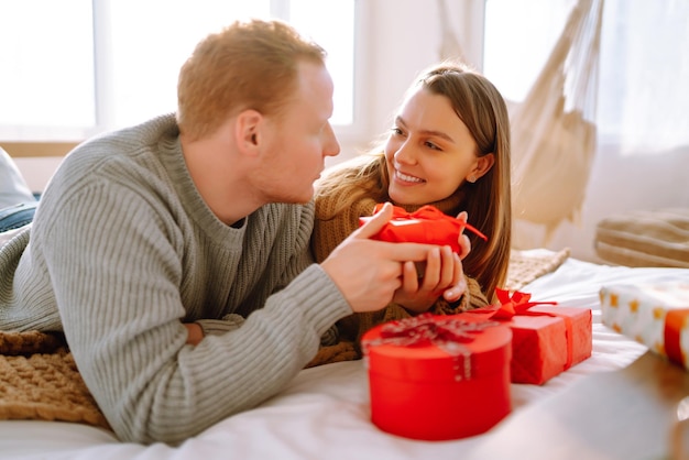 Valentine's Day concept Exchange of gifts Young couple at home celebrating Valentine's Day