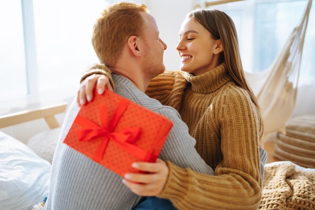 Photo valentine's day concept exchange of gifts young couple at home celebrating valentine's day