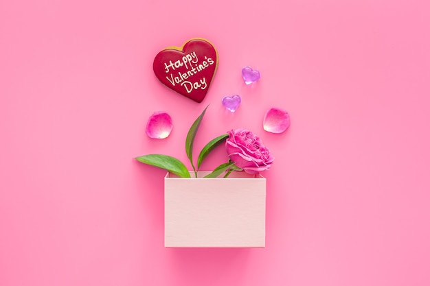 Valentine's day concept. Pink box with marmalade and macaroons and a beautiful rose on a pink table