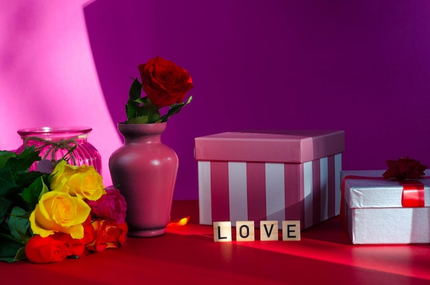 Концепция дня святого Валентина. Красная роза и подарочная коробка на красном фоне