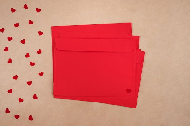 Valentine's day concept. Stack of red envelopes and paper hearts. Flat lay.