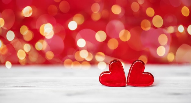 Valentine's day concept. Two shapes of red hearts on a red bokeh background. 