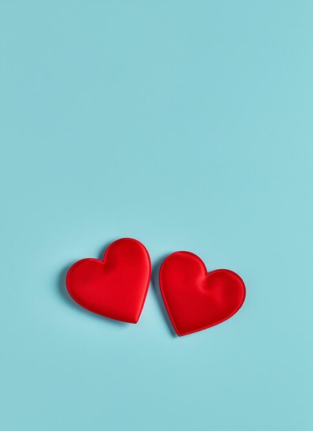 Photo valentine's day concept with two red hearts on light blue background top view