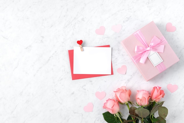 ピンクのバラの花と大理石の白い背景の上のギフトボックスとバレンタインデーのデザインコンセプトの背景