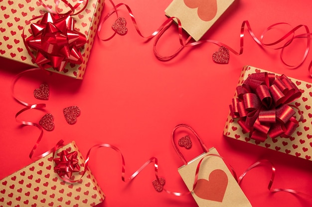 Фото Подарочная коробка на день святого валентина и сердечки на красном фоне