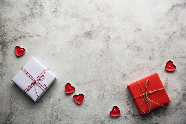 Valentine's Day, Gift box of kraft paper with a ribbon and candles on gray background.
