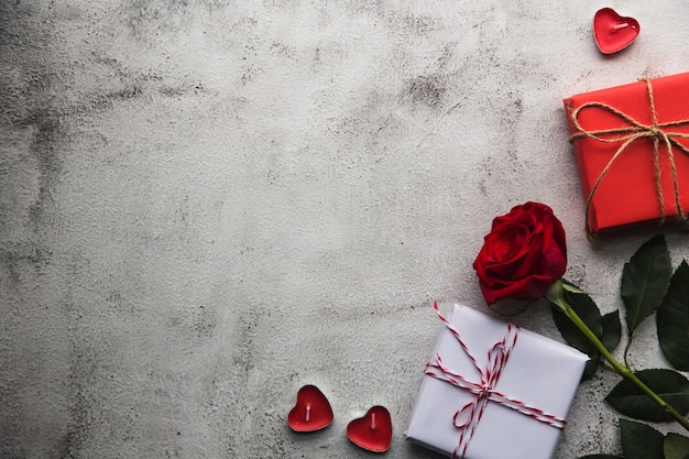 Valentine's Day, Gift box of kraft paper with a ribbon, rose and candles on gray background