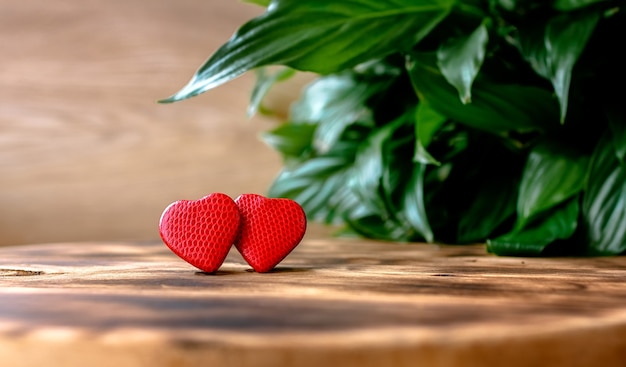 Valentine's day greeting card with two red hearts on a wooden rustic table