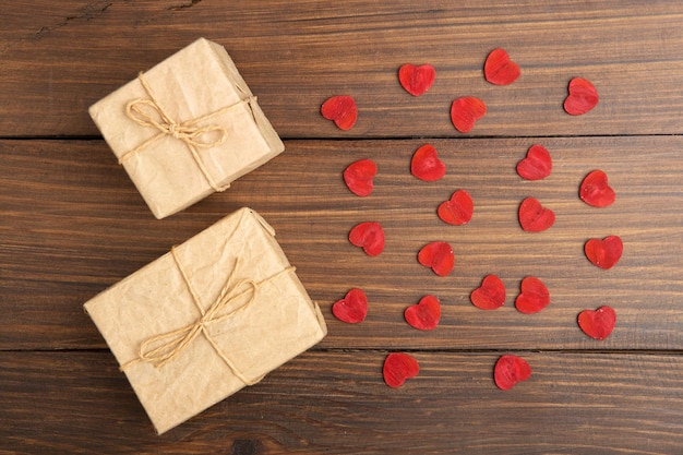 Valentine's Day greetings concept Little red wooden crafted hearts and gift boxes on the wooden background Valentines greeting card