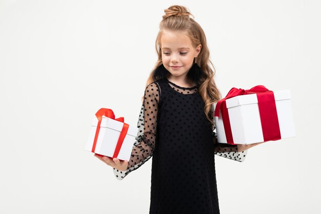 San valentino . il bambino felice tiene due regali nelle mani su un bianco