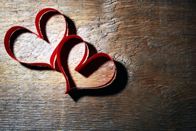 Valentine's Day heart made of ribbon on wooden background