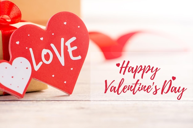 Concetto di design di vendita di promozione della cartolina d'auguri di san valentino con la decorazione rossa di forma del cuore del testo per il fondo del bokeh di amore felice si chiuda