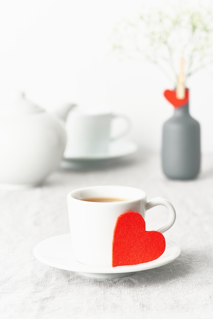 バレンタイン・デー。お茶と花を含む2人の朝の朝食。赤いフェルトの心
