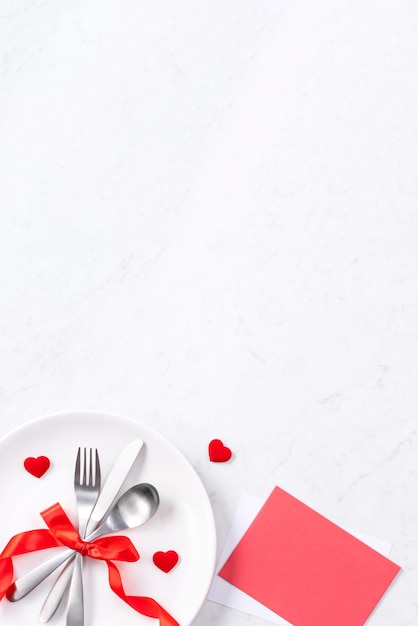 Foto san valentino festa della mamma vacanza incontri pasto banchetto concetto di design piatto bianco e nastro rosso su sfondo marmoreo vista dall'alto piatto