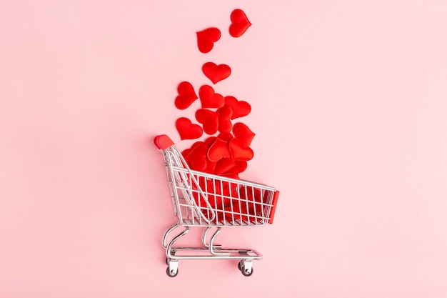 valentine's day pink flat lay, grocery cart and red heart