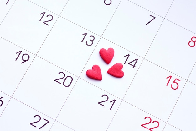 Valentine's day red hearts on calendar with 14 february date background, love, celebration concept