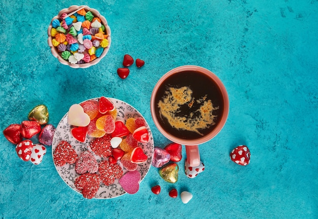 San valentino o cena romantica con cuori di caramelle, una tazza di caffè caldo e un'elegante tavola