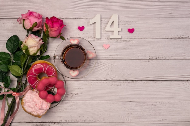 День Святого Валентина. Романтический утренний мотив, чай, роза и сладкие пончики.
