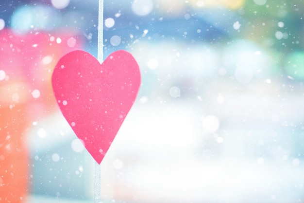 Valentine's day on a snowy winter day. decor of carved red paper in the form of a heart