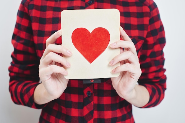 День святого Валентина, молодая блондинка держит открытку с сердцем в руках