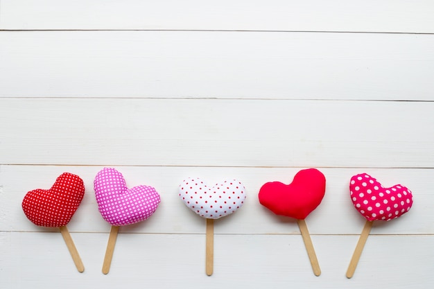 Valentine's hearts on white wooden background.