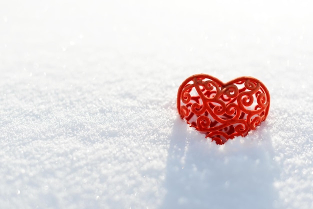 雪の中のバレンタイン 雪の背景にロマンチックな愛の赤いハートのシンボル。バレンタインデーのコンセプト