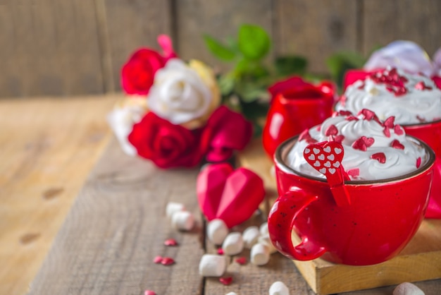 Valentine warme chocolademelk of koffie, twee rode kopjes met warme chocolademelk of latte drinken