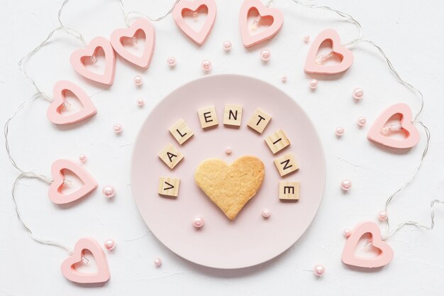 VALENTINE word and heart shaped cookie on a plate