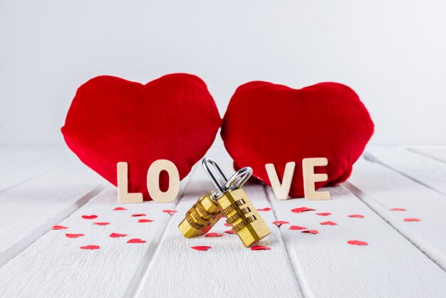 Valentines achtergrond met rood hart vorm en paar combinatie hangslot op witte houten tafel