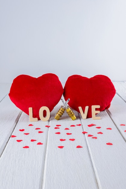 Valentines background with Red Heart shape and Couple Combination padlock on white wooden table