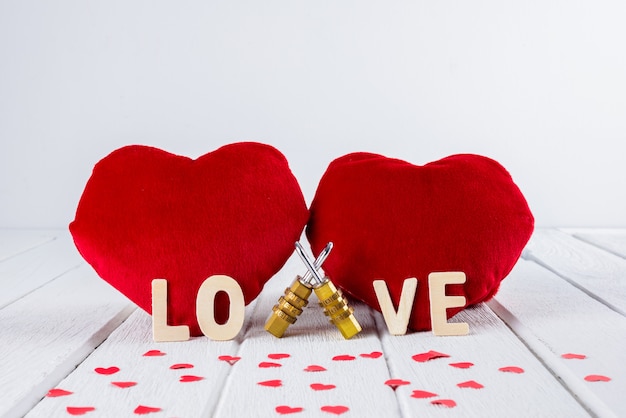 Valentines background with Red Heart shape and Couple Combination padlock on white wooden table