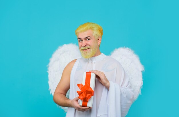 Valentines day angel cupid with gift love concept cupid smiling\
man in angel costume february cupid