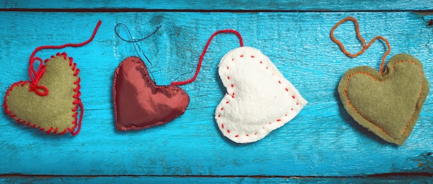 Valentines day Background. Multicolored knitted hearts lie on the blue old boards. Letter box look.