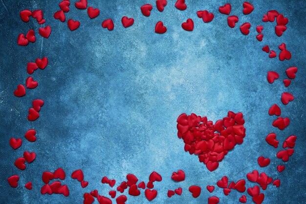 Valentines Day background. Red hearts frame on dark blue background. 