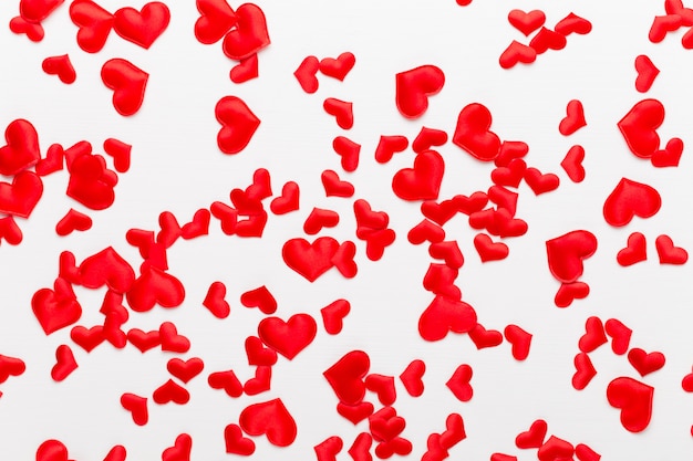 Valentines day background red hearts on white wooden background.