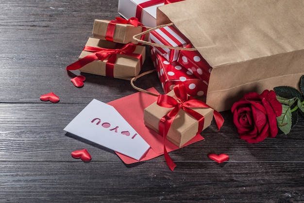 Fondo di giorno di biglietti di s. valentino, carta di giorno di biglietti di s. valentino con le rose e regali sul bordo di legno