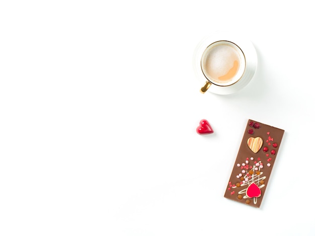 День святого валентина фон с шоколадно-красными сладостями в форме сердца и кофе на белом фоне