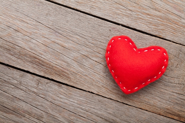 Valentines day background with handmade toy heart over wooden table