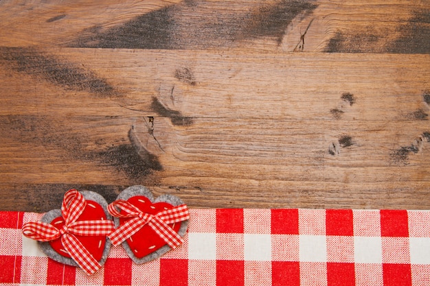 Valentines day background with handmade toy hearts over wooden table