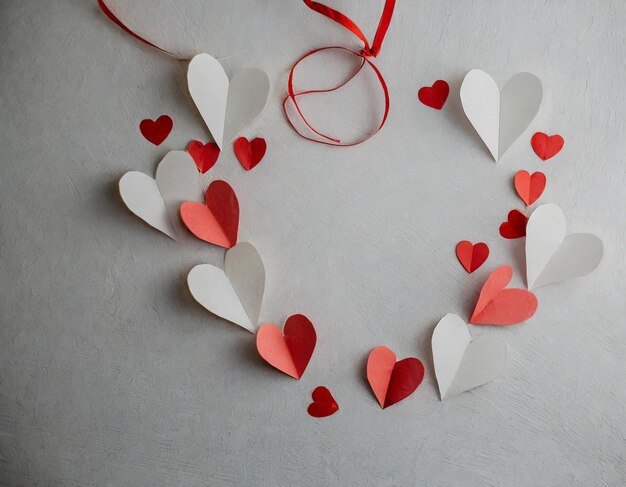 Фон дня святого Валентина с красными и белыми бумажными сердцами
