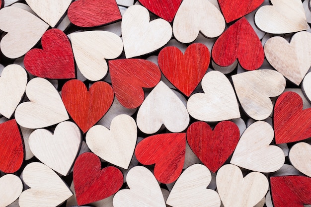 Valentines day background with white end red hearts on wooden background.