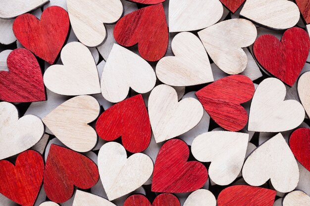 Valentines day background with white end red hearts on wooden background.