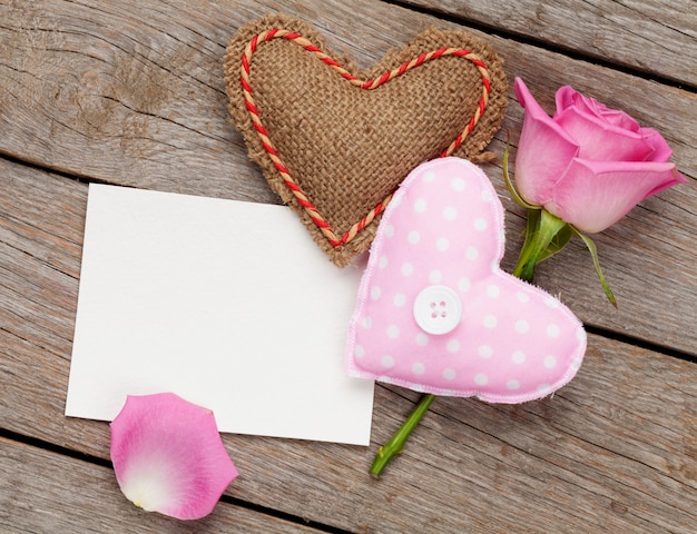 Cartolina d'auguri o cornice per foto in bianco di san valentino con i cuori del giocattolo fatti a mano e la rosa di rosa