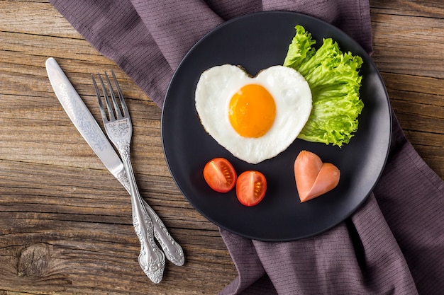 Valentines day breakfast with heart shaped fried eggs served on grey plate. flat lay, top view