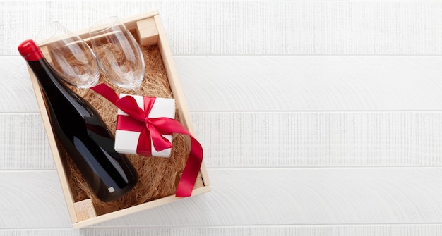 Photo valentines day or christmas gift box with red wine bottle top view flat lay with space for your greetings