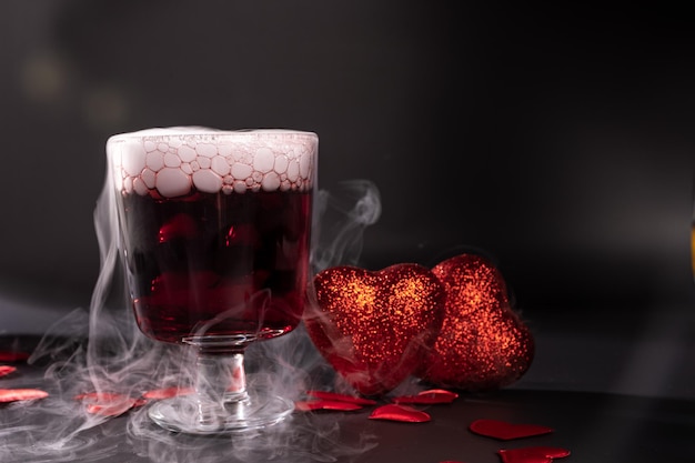 Valentines day cocktail with dry ice on dark background