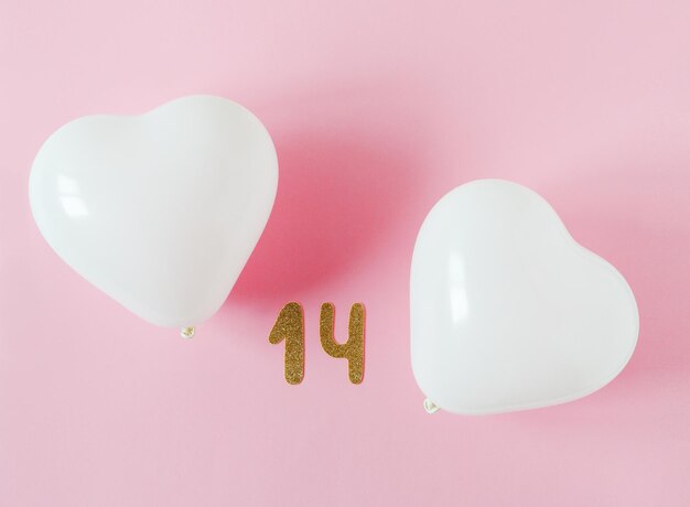 Valentines day composition. Pink background with white heart shape baloons. February 14 greeting