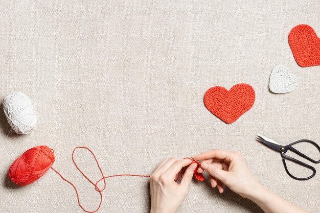 Foto preparazione del concetto del giorno di san valentino cucire cuori valentine donna mani cucire lavoro fatto a mano rosso