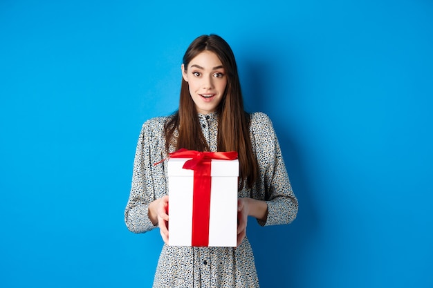 Valentines day concept surprised happy girl receiving romantic gift and looking thankful at camera s...