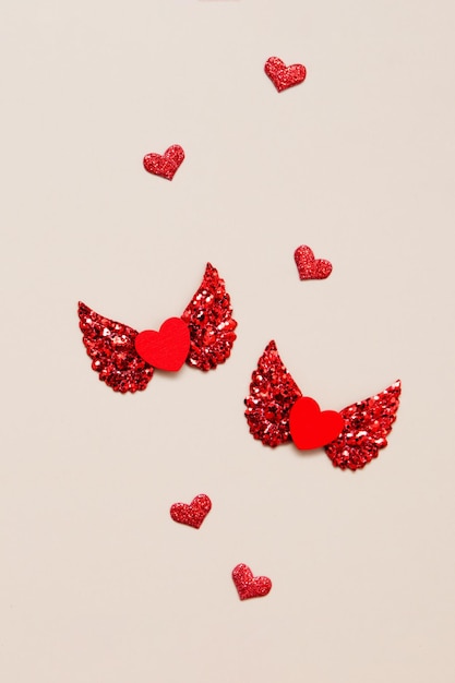 Valentines day concept two red hearts with wings top view. Creative love concept vertical photo